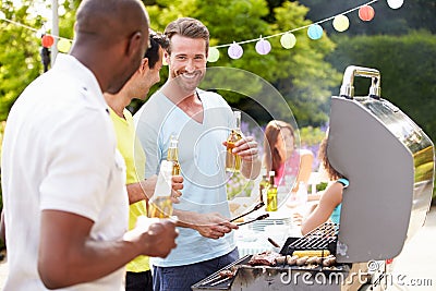Group Of Men Cooking On Barbeque At Home