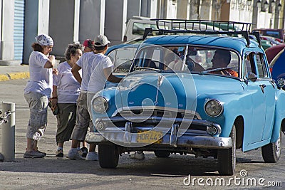 Group of people getting out ofold classic Cuban taxi car