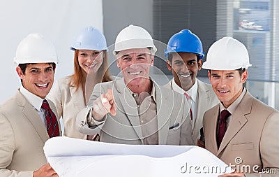 A group of smiling architects studying blueprints