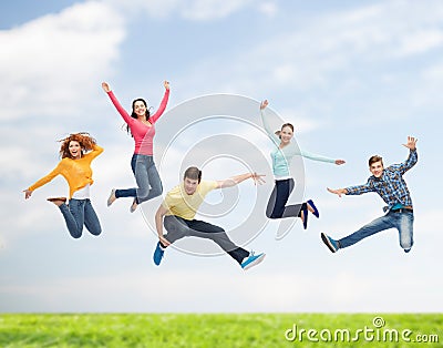 Group of smiling teenagers jumping in air