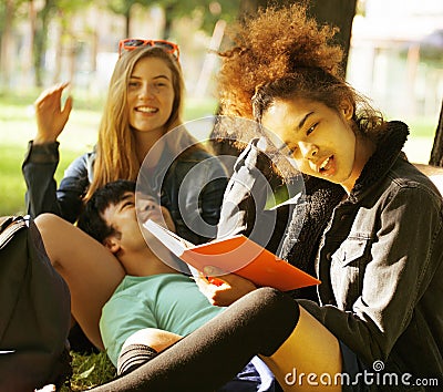Group of students on grass, prepaing to exam