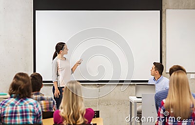 Group of students and smiling teacher in classroom