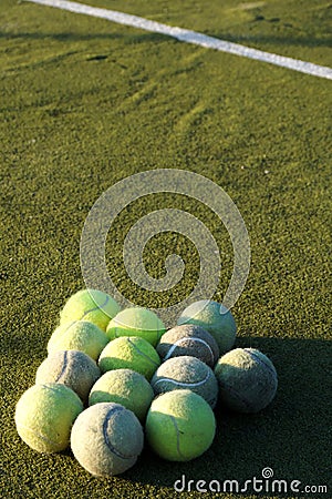 Group of tennis balls in front of white line on court