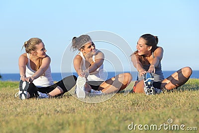 Group of three women stretching after sport