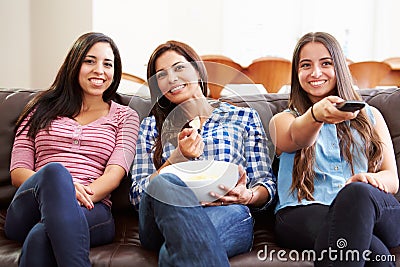 Group Of Women Sitting On Sofa Watching TV Together