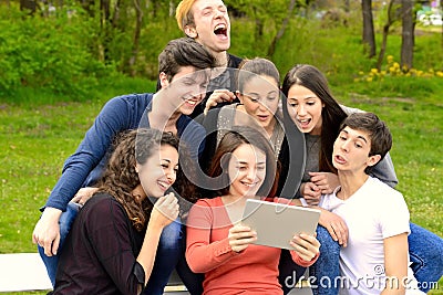 Group of young adults browsing a tablet outside