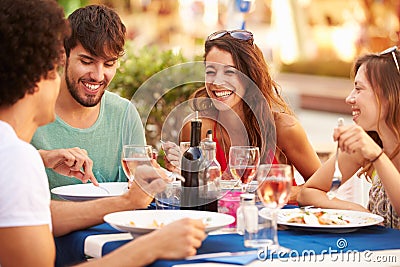 Group Of Young Friends Enjoying Meal In Outdoor Restaurant