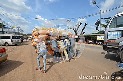 A group of young people pushing a cart overloaded bags