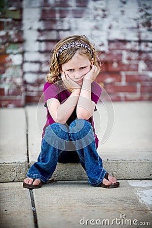 Grumpy Little Girl Sitting on Curb