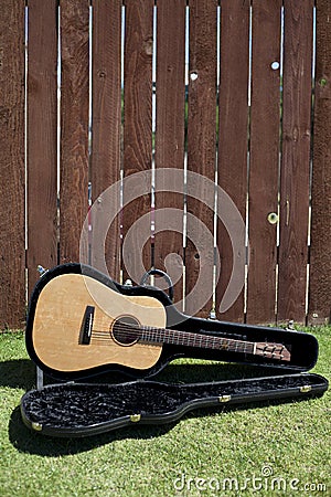 Guitar in Case Against a Fence