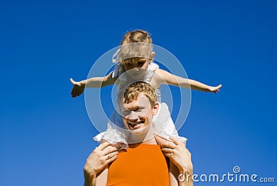 A guy holding a baby on his shoulders