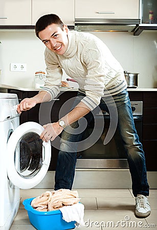 Guy loading clothes into the washing machineading clothes into