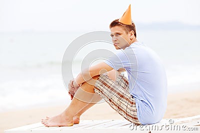 Guy in party hat on beach