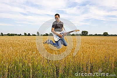 Guy Playing Electric Guitar In Wheat Field