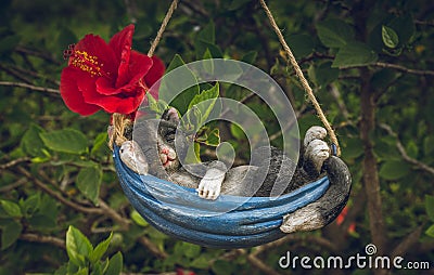 Gypsum cat sleeping in hammock