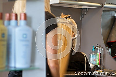 Hairdresser applying extensions to a client