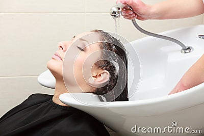 Hairstylist washing woman hair. Hairdressing beauty salon