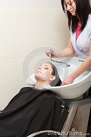 Hairstylist washing woman hair. Hairdressing beauty salon