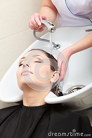 Hairstylist washing woman hair. Hairdressing beauty salon