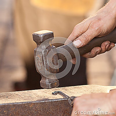 Hammer, anvil and the hands of blacksmith