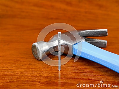 Hammer and nail on wooden background