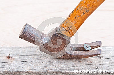 Hammer pulling out a nail out of a piec