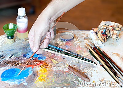 Hand of the artist with a paintbrush