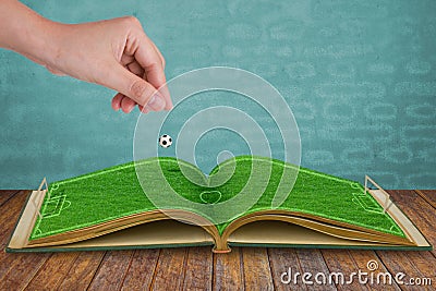 Hand drop football down to green grass