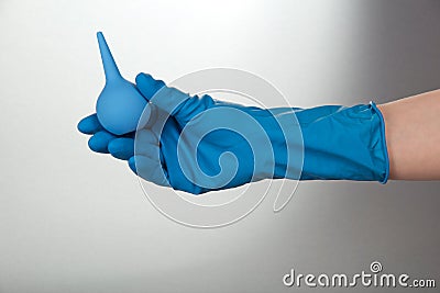 Hand in glove, holding small enema