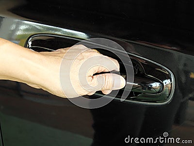 Hand is going to pull a car s door handle