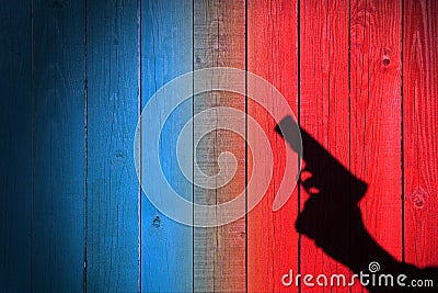 Hand with a gun on a wooden fence