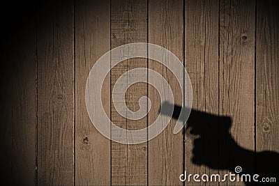 Hand with a gun on a wooden fence