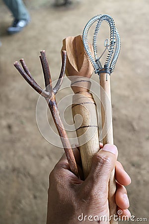 Hand holding different wicks to mix the cocoa to make chocolate drink