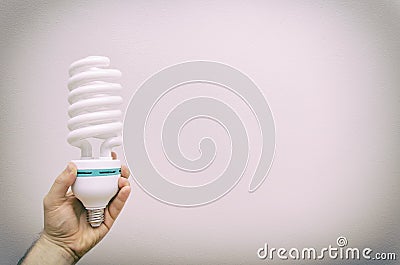 Hand holding fluorescent lamp.