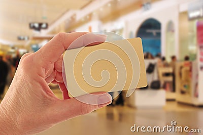 Hand Holding Gold Credit Card in Shopping Mall