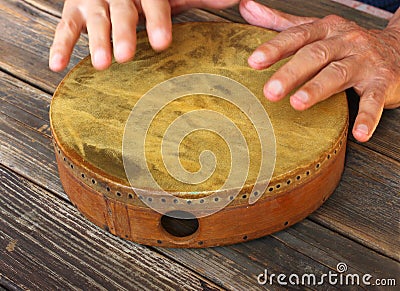 Hand in motion of senior man playing ethnic drum