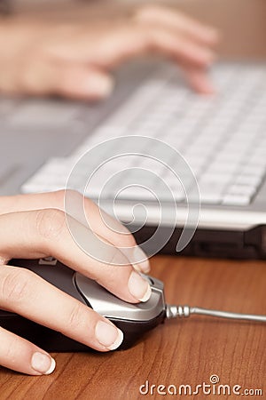 Hand on mouse and keyboard blured