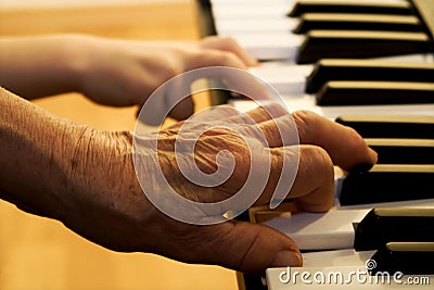 Hand of old piano player and child