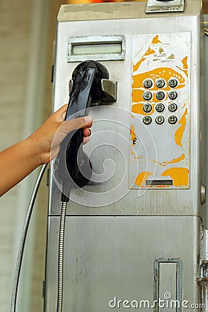 Hand and old vintage phone booth.