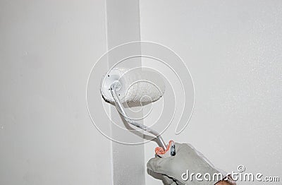 Hand painting a wall with a paint roller