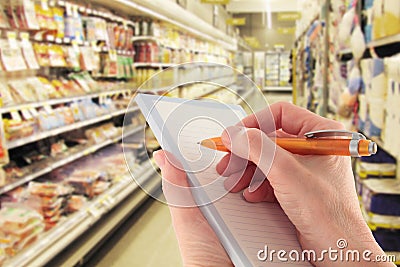 Hand with Pen Writing Shopping List in Supermarket