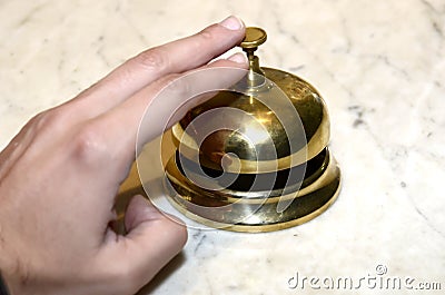 Hand playing a hotel bell