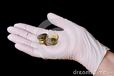 Hand in surgical gloves with five coins