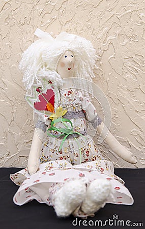 Handmade doll with a flower in his belt in a long white dress si