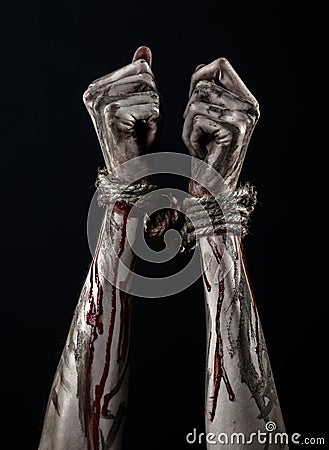 Hands bound,bloody hands, mud, rope, on a black background, isolated, kidnapping, zombie, demon