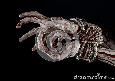 Hands bound,bloody hands, mud, rope, on a black background, isolated, kidnapping, zombie, demon