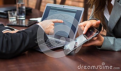 Hands of businessman and businesswoman with laptop,mobile tablet.