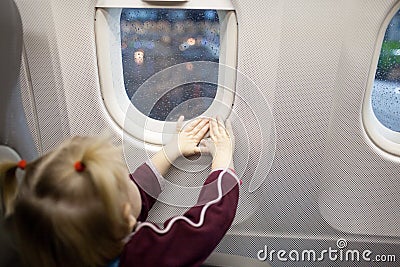 Hands of child in the window of airplane
