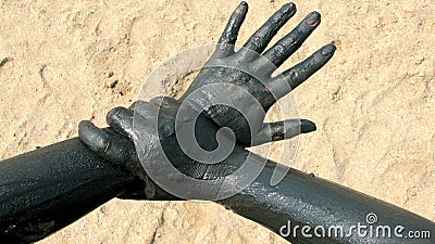 Hands covered with therapeutic mud at Techirghiol