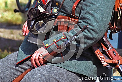 Hands of a German soldier-reenactor holding a gun.